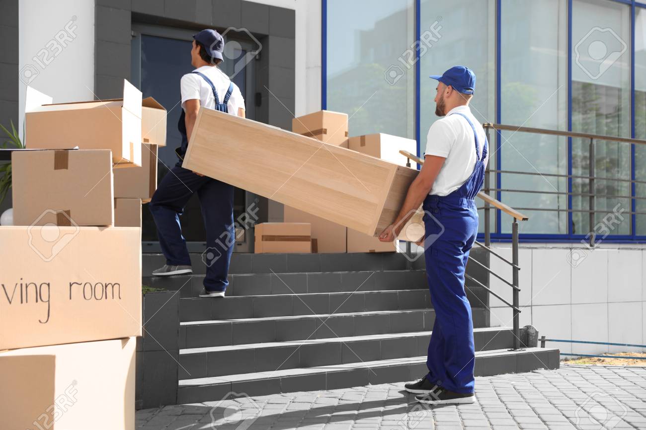 Male movers carrying shelving unit into new house Male movers carrying shelving unit into new house